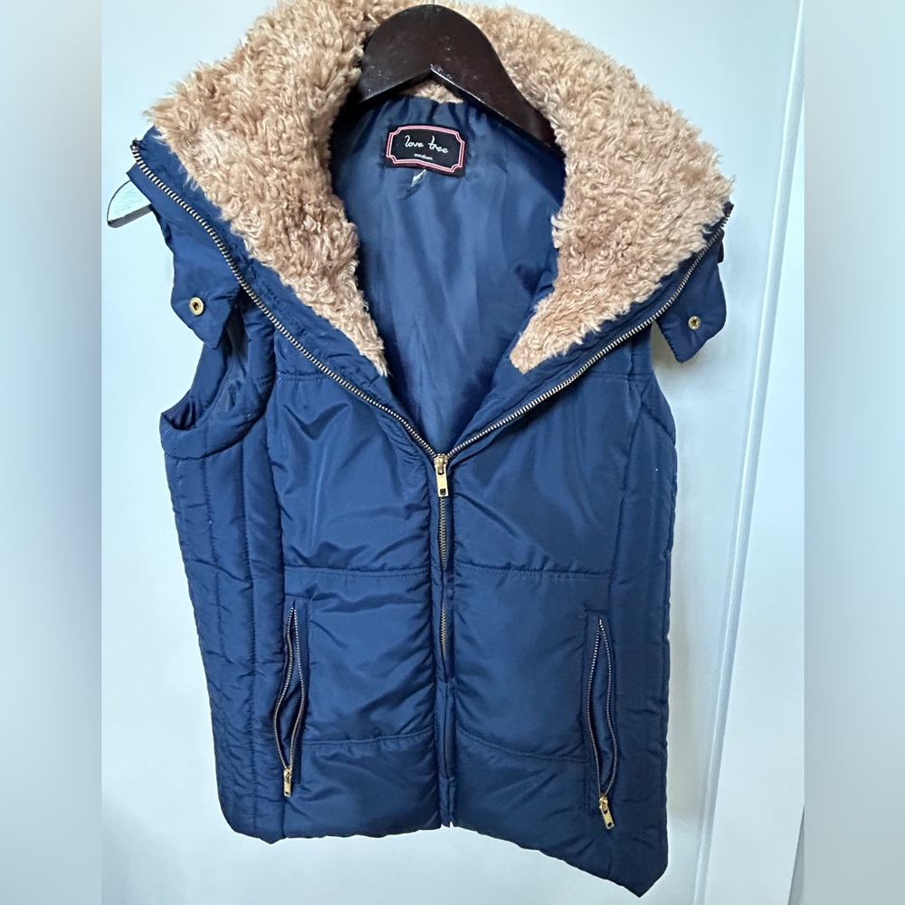 Women’s navy puffer vest with fleece hood.